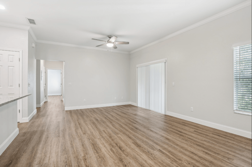 A room with wooden flooring and a ceiling fan.
